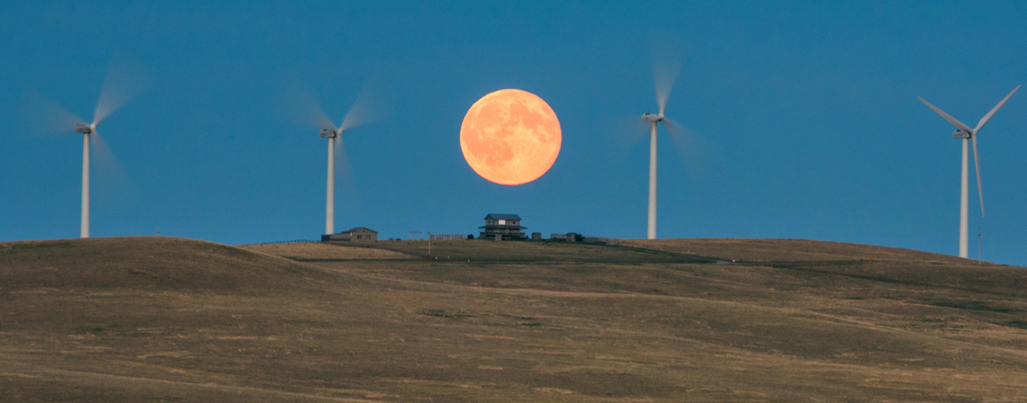 [Translate to English:] Full moon rising over wind turbines by Jeff Wallace / flickr / CC BY-NC 2.0